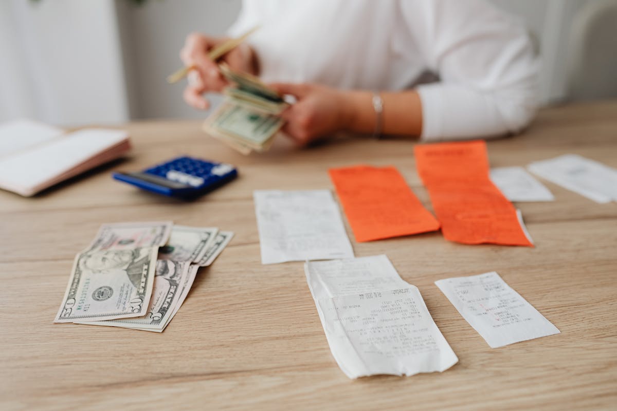 Person reviewing financial documents and cash for household budget